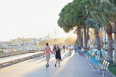 Persone che camminano lungo la Croisette a Cannes in un pomeriggio d'estate.