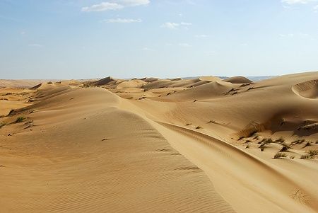 Dune di sabbia nel deserto di Rub al Khali, Oman, sotto un cielo limpido.