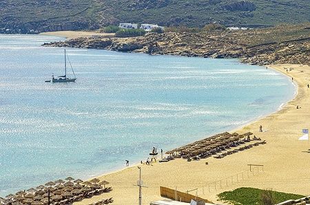 Vista aerea di Elia Beach a Mykonos con mare blu e ombrelloni.