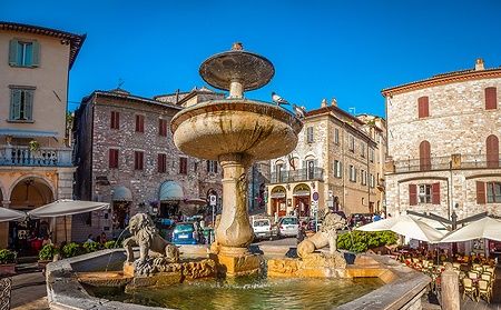 Fontana antica con leoni nella Piazza del Comune ad Assisi, Umbria, Italia.