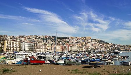 Golfo di Napoli con barche colorate e edifici lungo il Lungomare.