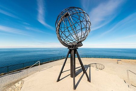 Sfera di metallo su promontorio con mare e orizzonte a North Cape, Finnmark.