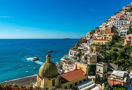 Vista di Positano con la chiesa di Santa Maria Assunta e il mare blu.
