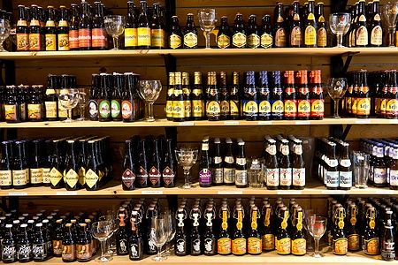 Scaffali pieni di bottiglie di birra colorate in un negozio di Bruges, Belgio.