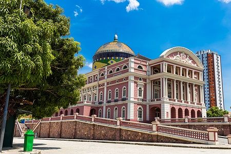 Teatro Amazonas a Manaus, Brasile, con facciata storica e cupola colorata sotto un cielo blu.