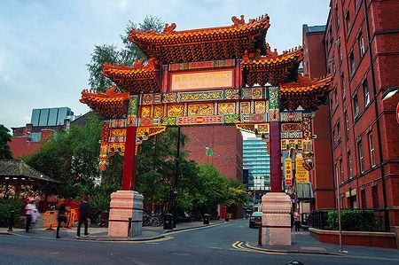 Arco colorato di Chinatown su Faulkner Street a Manchester, con edifici circostanti.