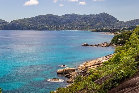 Baia di Beau Vallon a Mahé, Seychelles con acque turchesi e rocce.