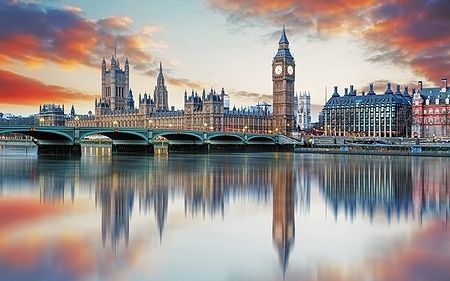 Il Big Ben e le Houses of Parliament si riflettono nel Tamigi al tramonto.