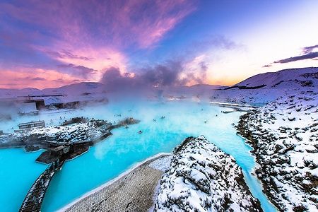 Blue Lagoon vicino Reykjavik con acque turchesi e paesaggio innevato al tramonto.