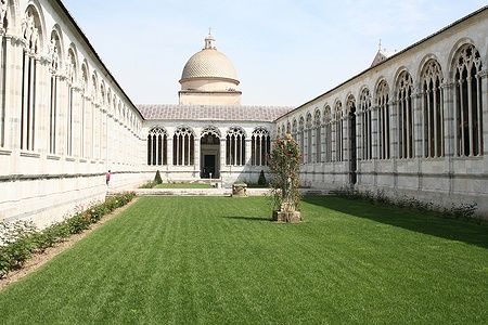 Il Camposanto di Pisa con archi gotici e un prato centrale.