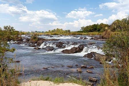 Popa Falls in Caprivi, Namibia, con rapide e vegetazione rigogliosa.