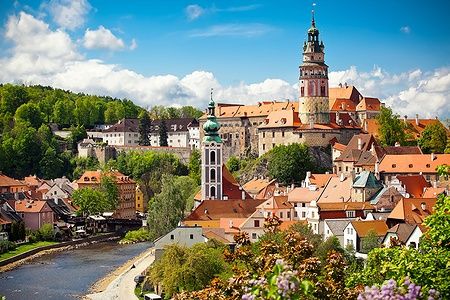 Veduta della chiesa e del castello di Cesky Krumlov con tetti rossi e cielo blu.