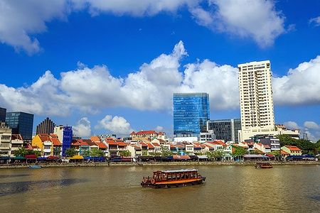 Edifici colorati lungo il fiume a Clarke Quay, Singapore, sotto un cielo azzurro.