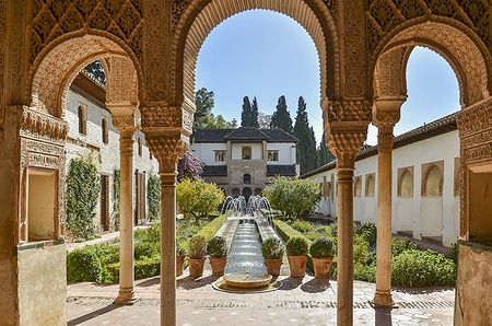 Giardino del Palacio de Generalife a Granada con fontana e archi moreschi.