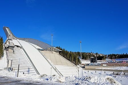 Il trampolino Holmenkollen a Oslo sotto un cielo blu invernale.