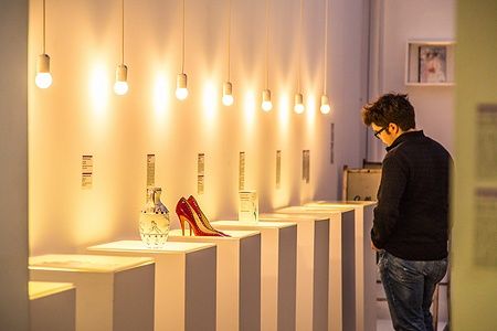 Individuo osserva oggetti esposti nel Museo delle Relazioni Interrotte a Zagabria.