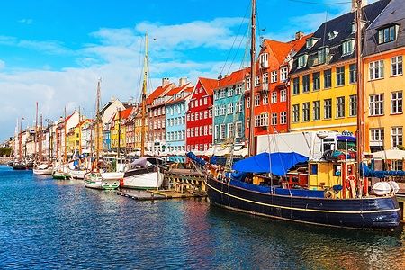 Nyhavn a Copenaghen con edifici colorati e barche sul molo.