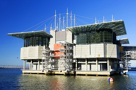 Oceanario de Lisboa, una struttura moderna sull'acqua in una giornata soleggiata.