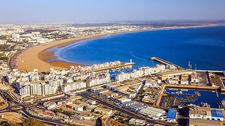 Vista panoramica di Agadir, Marocco, con spiaggia e oceano da una montagna.