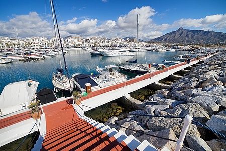 Porto turistico di Puerto Banus con yacht e montagne sullo sfondo.