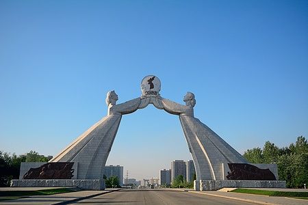Monumento alla Riunificazione a Pyongyang, con due statue che sostengono una mappa della Corea.