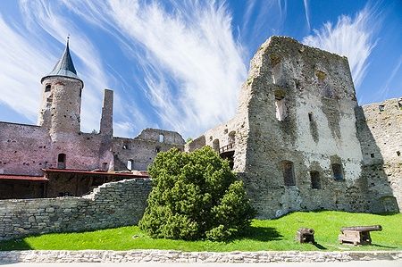 Rovine del castello di Haapsalu con cannoni sul prato.