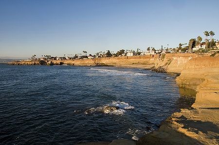 Scogliere di San Diego al tramonto con cielo sereno e onde del Pacifico.