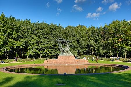 Scultura di Chopin nel Parco Łazienki di Varsavia, con alberi e laghetto.