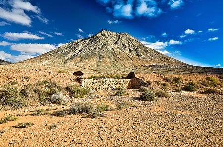 Vista della montagna di Tindaya a Fuerteventura, con paesaggio arido sotto un cielo azzurro.
