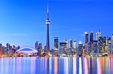 Skyline di Toronto con riflessi nel lago e la CN Tower sullo sfondo.