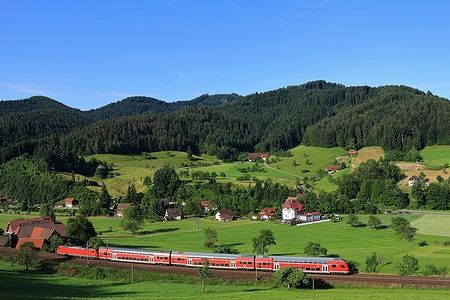 Treno rosso nel paesaggio estivo della Foresta Nera in Germania.