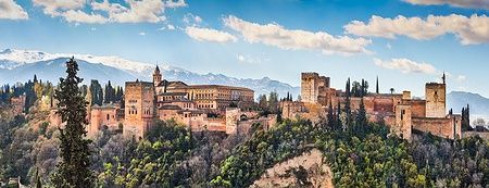 Vista panoramica dell'Alhambra di Granada con montagne sullo sfondo.