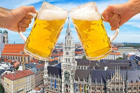 Due boccali di birra brindano davanti alla Marienplatz di Monaco durante l'Oktoberfest.