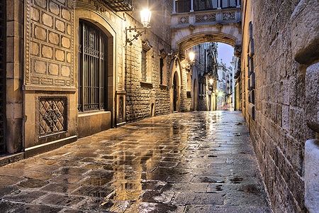 Via stretta illuminata nel quartiere gotico di Barcellona.