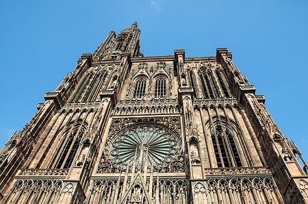 Facciata gotica della Cattedrale di Strasburgo sotto un cielo blu.