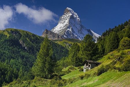 Il Cervino sopra Zermatt in estate, con una capanna e verdi prati.