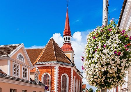 La Chiesa di Sant'Elisabetta a Pärnu, Estonia, con mattoni rossi e fiori in primo piano.