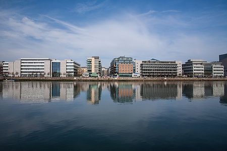 Edifici moderni del Dublin Docklands riflessi sull'acqua calma.
