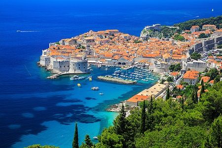 Vista panoramica della Città Vecchia di Dubrovnik con il mare turchese e le mura storiche.