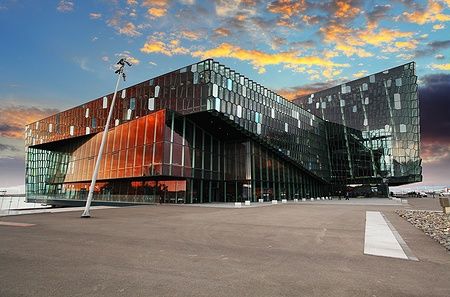 Harpa Concert Hall a Reykjavik al crepuscolo, riflesso nel cielo colorato.