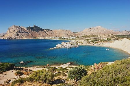 Costa di Kolymbia, Rodi, con mare cristallino e montagne sullo sfondo.