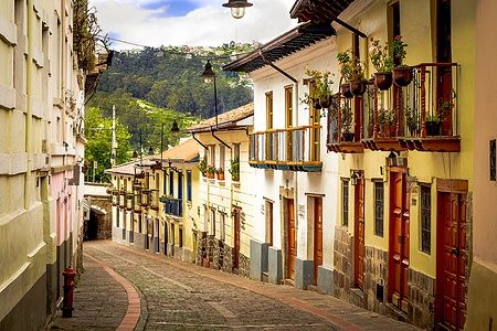 Strada pittoresca di La Ronda con edifici colorati e balconi fioriti a Quito.