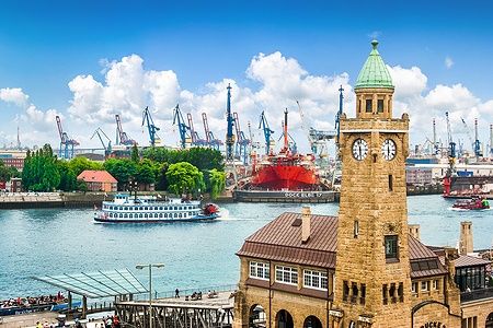 Landungsbrücken ad Amburgo con battello a vapore e gru portuali.