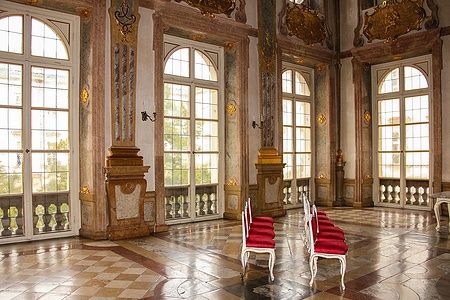 Interno del Marmorsaal nel Palazzo Mirabell a Salisburgo, Austria, con sedie rosse e decorazioni dorate.