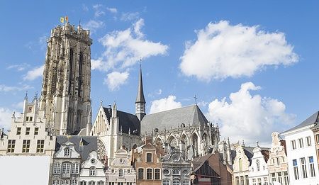 La Cattedrale di San Rombaldo e la Grote Markt a Mechelen sotto un cielo azzurro.