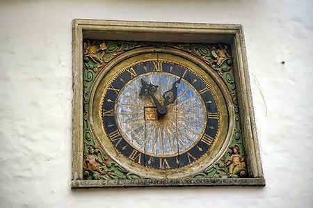 Orologio antico ornato su parete bianca a Tallinn, Estonia.