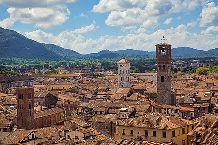 Panorama di Lucca dai tetti rossi e colline sullo sfondo.