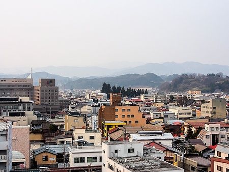 Vista aerea di Takayama, Giappone, con tetti e colline in lontananza.