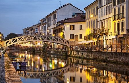 Ponte sul Naviglio Grande illuminato di sera a Milano.