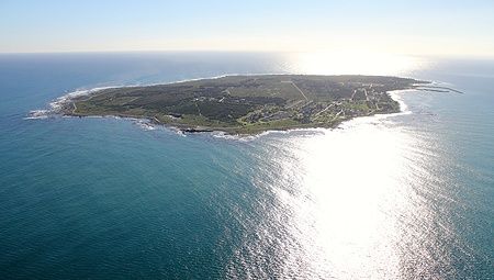 Vista aerea di Robben Island al tramonto con riflessi sull'acqua.